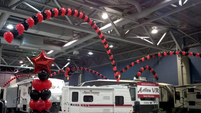 Arches de ballons rouges et noirs à l'hélium pour une exposition de roulottes