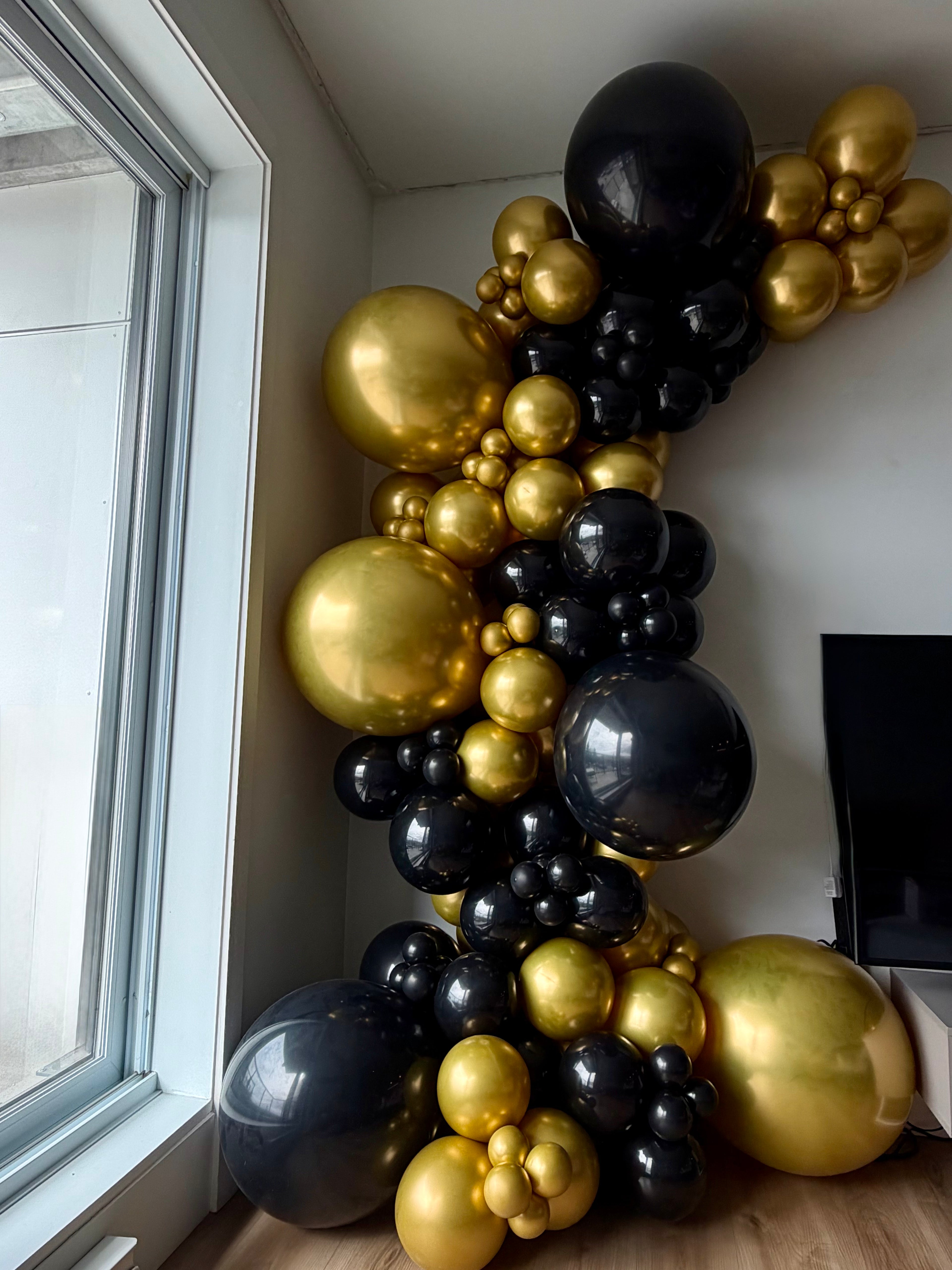 Arche de ballons noir et or sur le mur sans support à Québec