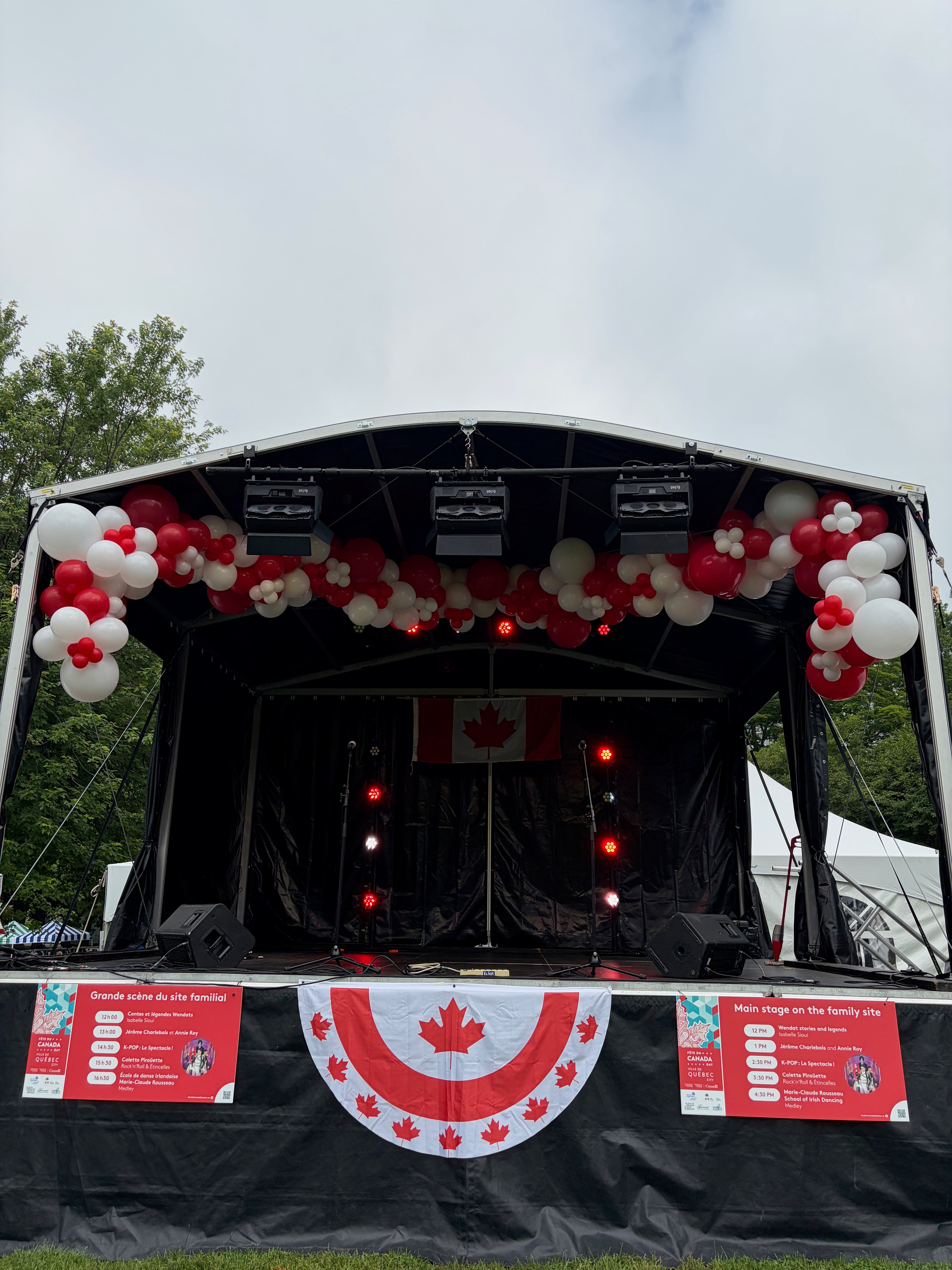 Guirlande de ballons blancs et rouges installée sur une scène pour la Fête du Canada à Québec